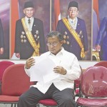 Menko Perekonomian Darmin Nasution membaca bahan hasil rapat kabinet terbatas sebelum mengumumkan Paket Kebijakan Ekonomi Jilid Enam di Kantor Kepresidenan, Jakarta, Kamis (5/11).